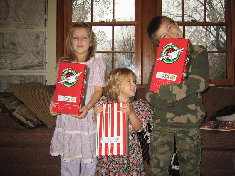 IMG_8426.JPG - Three kids (the ones who cared) showing off the shoeboxes they packed up with Christmas gifts.