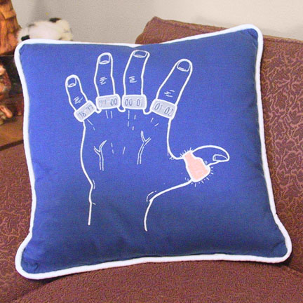 03-pillow.jpg - A pillow made from a special T-shirt and edged with piping.  (The other side of the pillow is the logo from the front of the shirt)
